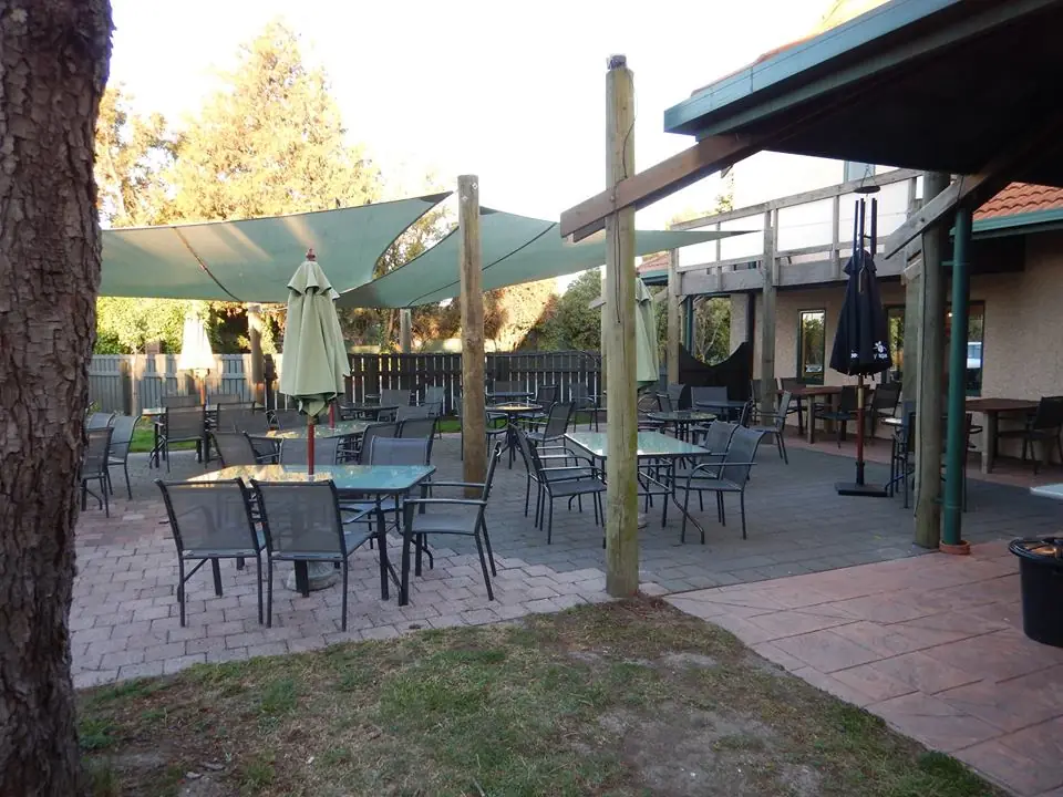 The courtyard: shade sails, umbrellas and tables on brick paving