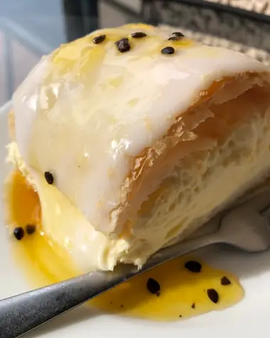 A guest’s photo of the custard square: thick custard between flaky pastry, under passionfruit icing
